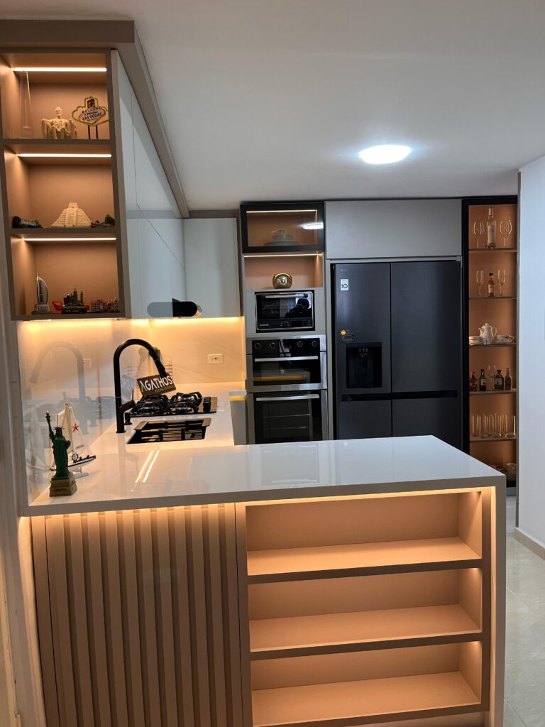Cocina integral Color Ámbar Mate en la parte inferior, puertas superiores en Lamina Alto brillo, vitrina con luces led y puerta en aluminio con Vidrio Bronce y Mesón en Piedra Sinterizada.